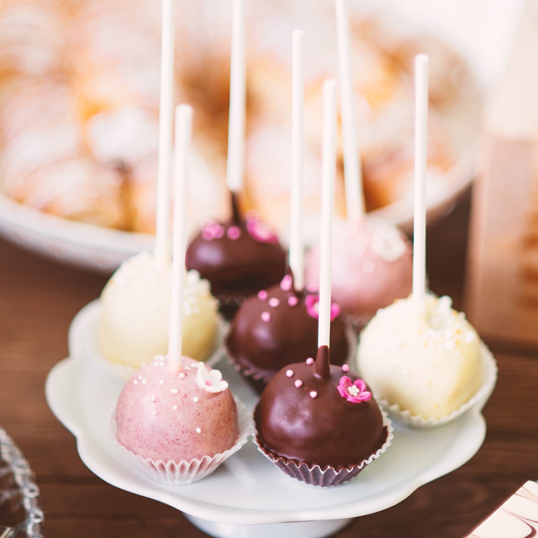 Cake pops on cakestand, tarts and cupcakes. Candy bar.