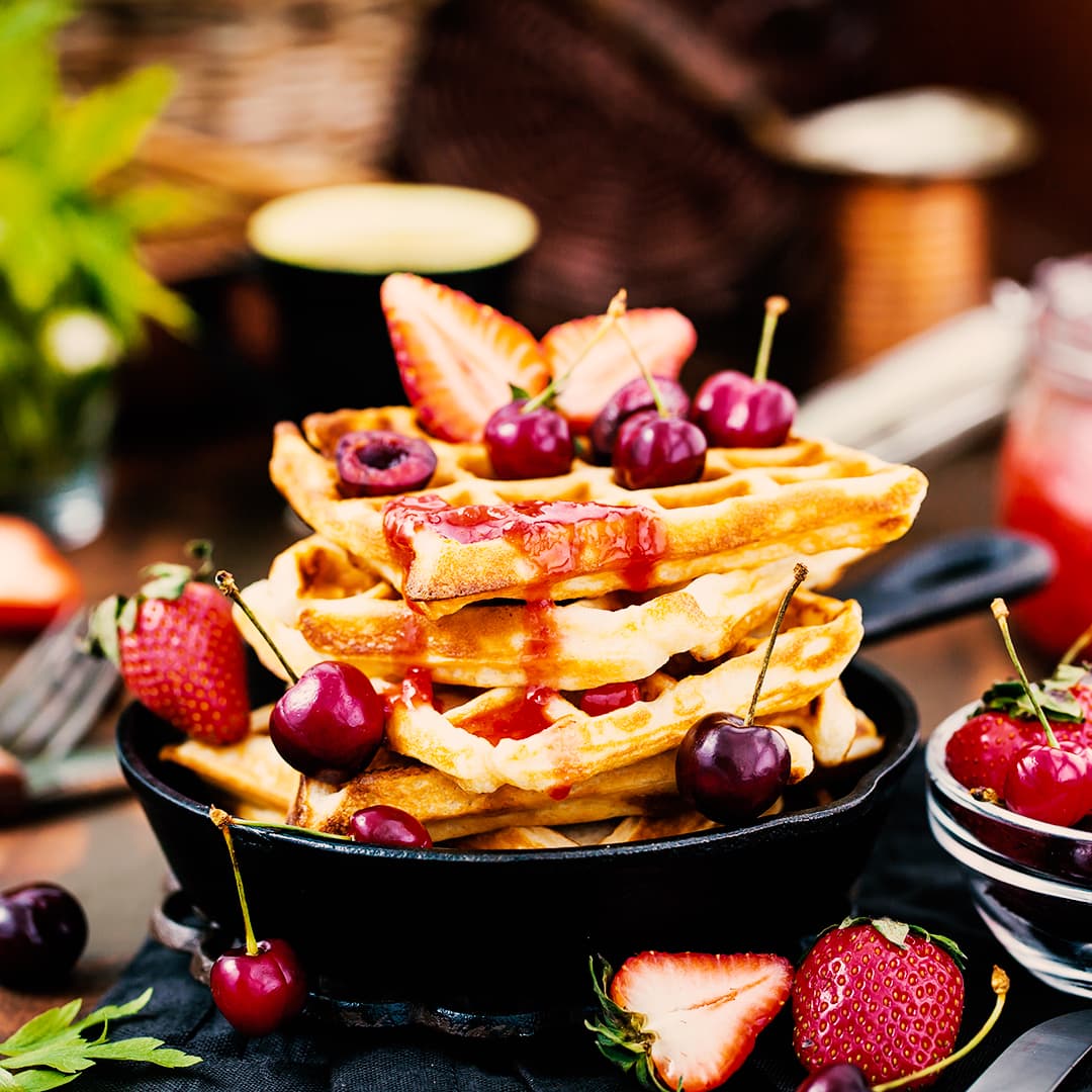 Belgian waffles with fresh berries and jam for breakfast